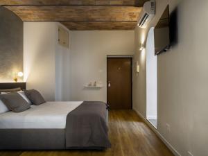 een slaapkamer met een bed en een flatscreen-tv bij Ave Luxury Suite - By OpenRoma in Rome