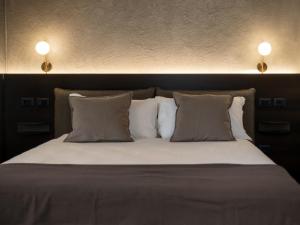 een bed met twee kussens en twee lampen erboven bij Ave Luxury Suite - By OpenRoma in Rome +6 foto's