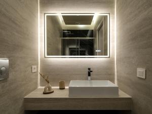 een badkamer met een witte wastafel en een spiegel bij Ave Luxury Suite - By OpenRoma in Rome