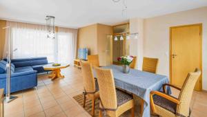 a living room with a table and a blue couch at Ferienwohnung Dominique in Nieder-Saulheim