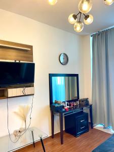- un salon avec une télévision et une table avec un miroir dans l'établissement AlenaHome, à Sabkhah