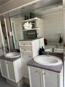 a bathroom with two sinks and a large mirror at ROBERT Aline in Saint-Jean-de-Bassel
