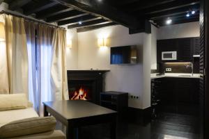 a living room with a fireplace and a couch at La Plaza in Hervás