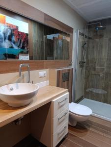 ein Badezimmer mit Waschbecken, Toilette und Dusche in der Unterkunft Domek Loft z Balią Jacuzzi i sauną na wyłączność Dowspuda 