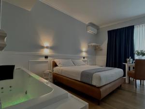 ジュリアーノ・イン・カンパーニアにあるHotel Barbarella Swimmingのベッドとバスタブ付きのホテルルームです。 +9枚の写真
