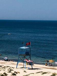 a life guard chair on a beach with the ocean at Appartement S2 cotè mer Soviva Kantaoui in Hammam Sousse +1 photo