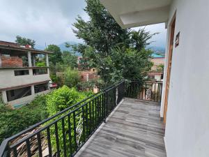 a balcony of a house with a wooden walkway at HABITAT Holiday Home in Dharmsala
