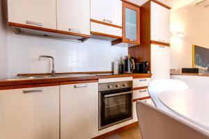 ノートにあるCasa Vico Ferruccio 24のキッチン(白いキャビネット、シンク、コンロ付)
