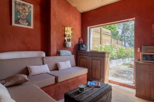un salon avec un canapé et une fenêtre dans l'établissement L'hôtel des oiseaux, aux Baux-de-Provence