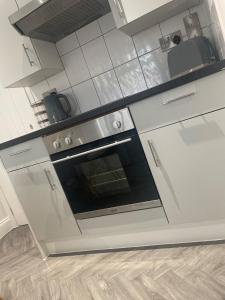 a kitchen with white cabinets and an oven at Luxury Retreat with Private Hot Tub in Cawston +16 photos