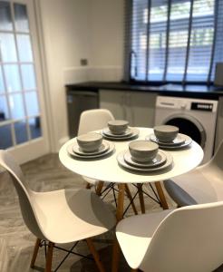 a white table and chairs in a kitchen at Luxury Retreat with Private Hot Tub in Cawston