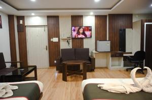 Una sala de estar con un sofá y un televisor. en Rudra Group, en Guwahati