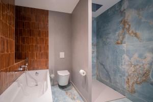 a bathroom with a tub and a toilet and a sink at Apartment 2 Bedrooms & Terrace - Fully Air-Conditioned - King Size Beds in Sélestat