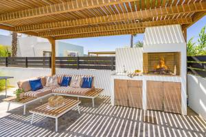 a patio with a couch and a fireplace at Villa Palm Vista by Villa Plus in Kremasti