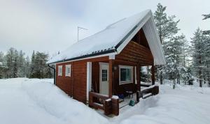 una pequeña cabaña en la nieve con nieve en Hulhavantuvat 1, en Syöte
