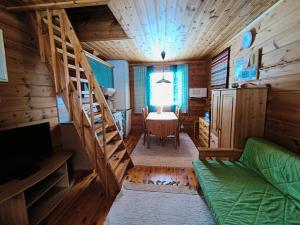 una sala de estar con una escalera en una cabaña de madera en Hulhavantuvat 1, en Syöte