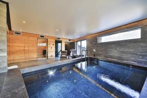 a swimming pool in a house with a living room at Chalet Kuma in Les Houches
