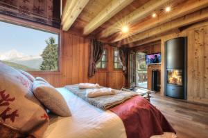 a bedroom with a bed with a fireplace and a tv at Chalet Nidaya in Les Houches