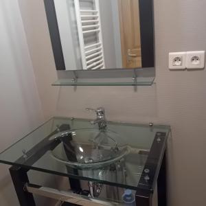 - Baño con lavabo de cristal y espejo en gîte La Belle Vue, en La Hoube