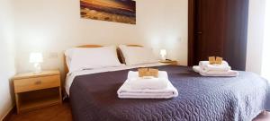 a bedroom with a bed with towels on it at Su Arghentu Country Hotel in Laerru