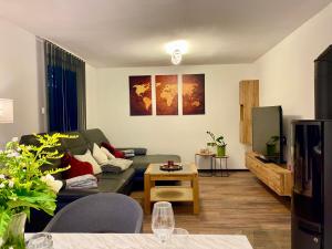 a living room with a couch and a table at Landhaus Sonnengarten - komplettes Haus mit Garten in Langegg