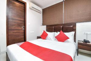 a bedroom with a large bed with red pillows at Hotel O Alandi Markal Crossway Formerly Shetkari Mala Lodging in Pune