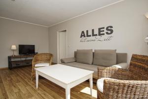 a living room with a couch and chairs and a table at strandnah mit Balkon, gratis Nutzung vom AHOI Erlebnisbad und Sauna in Sellin - Strandhaus Mönchgut FeWo16 in Lobbe