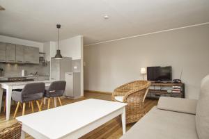 a living room with a white table and chairs at strandnah mit Balkon, gratis Nutzung vom AHOI Erlebnisbad und Sauna in Sellin - Strandhaus Mönchgut FeWo16 in Lobbe
