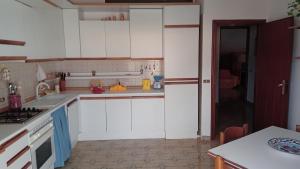 a kitchen with white cabinets and a counter top at Appartamento Napodano in Tortora