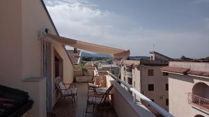 a balcony with chairs and tables on a building at Appartamento Napodano in Tortora