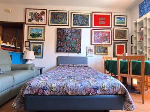 Un dormitorio con una cama y una pared de cuadros. en Artist's House Colosseum, en Roma