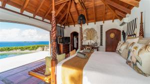 Un dormitorio con una cama y vista al mar. en Luxurious Oceanfront Villa in St Barths, en Quartier de Lorient