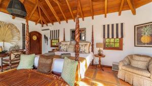 Un dormitorio con una cama y una sala de estar. en Luxurious Oceanfront Villa in St Barths, en Quartier de Lorient