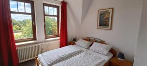 a bedroom with two beds and two windows at Huus Am Streek Padd in Cuxhaven