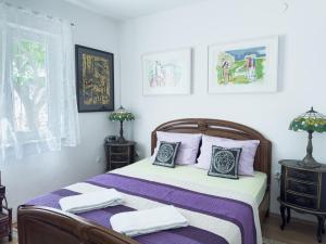 a bedroom with a bed with purple sheets and pillows at Luxury Beachfront Apartments Matista in Trogir