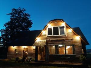 a house lit up at night with lights on it at Holiday house Mežmuiža in Rucava