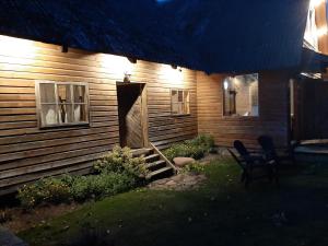 a house with a door and a chair in front of it at Holiday house Mežmuiža in Rucava