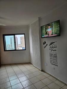 a room with a flat screen tv on the wall at kitnet Studio Vale a Pena Conferir! Vila ocian Praia Grande SP in Solemar