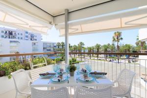 a white table and chairs on a balcony at UHC Formentor Apartments in Salou