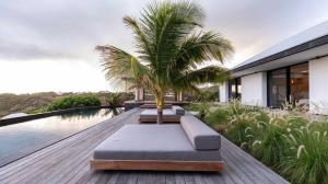 a palm tree sitting on the deck of a house at Luxurious Villa with Ocean Views in Pointe Milou in Pointe Milou