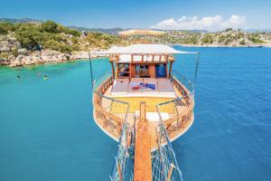 Güvercin AdasıYourTourKey Gulet's的坐在海滩旁的水面上的船