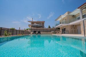 a large swimming pool in front of a house at Elysia Apartment in Pogoniá