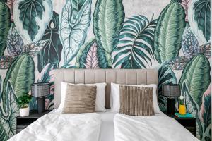 a bedroom with a bed with a tropical wallpaper at A60 Apartment Hotel in Budapest