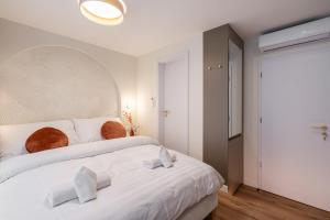 um quarto com uma grande cama branca com dois travesseiros em Asbóth Boutique Suites, Best Location by BQA em Budapeste