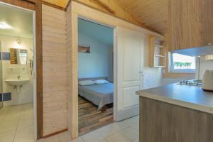 a kitchen with a room with a bed and a sink at 11 kopų in Šventoji