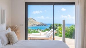 ToinyにあるOceanview Villa with Heated Poolのベッドがあり海が見える寝室