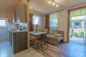 a small kitchen and living room with a table in a tiny house at 11 kopų in Šventoji +14 photos