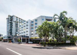 a hotel on the side of a street with palm trees at Novotel Darwin CBD in Darwin