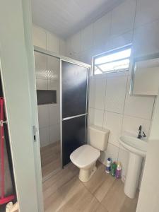 a bathroom with a toilet and a sink at Micro casa Maju in Cascavel +4 photos