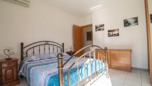 a bedroom with a bed and a wooden dresser at Domus Peppi in Villasimius